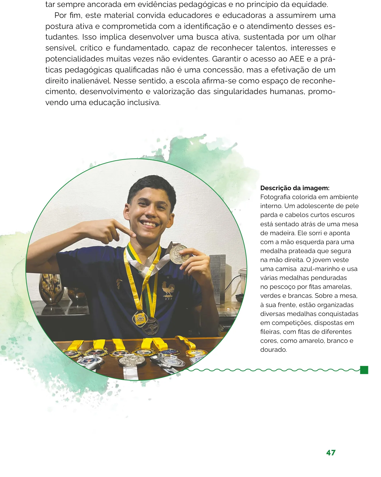 Fotografia de um adolescente sorridente apontando para uma medalha prateada que segura na mão, com várias medalhas penduradas no pescoço e outras organizadas sobre a mesa